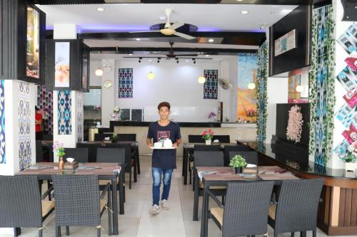 a woman is standing in a dining room at Diamond Crown in Patong Beach
