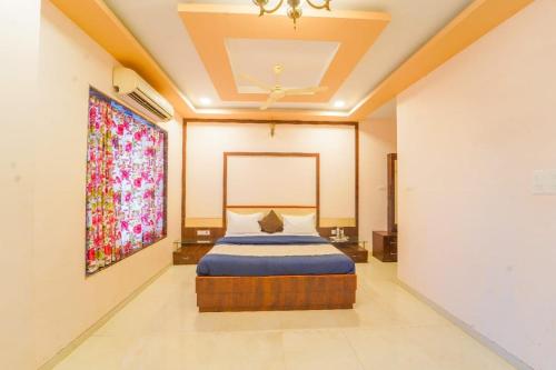 潘奇加尼的住宿－Zenith Villa，卧室配有一张床,墙上挂有绘画作品