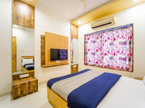 ein Schlafzimmer mit einem Bett und einem großen Fenster in der Unterkunft Zenith Villa in Panchgani