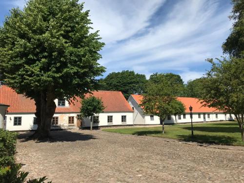 a row of white buildings with red roofs at korsholt-natur 135E in Sindal