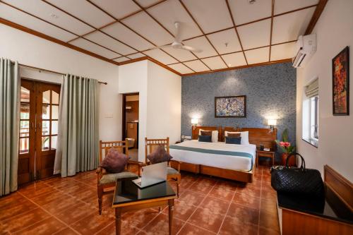 a hotel room with a bed and a desk at Backwater Ripples Kumarakom in Kumarakom