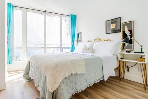 a bedroom with a bed and a large window at lovely 1-bedroom w/parking at Coal Harbour in Vancouver