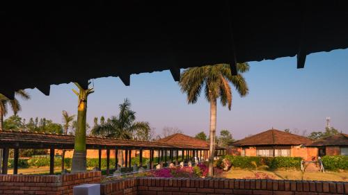 a resort with palm trees and a building at Hokke Lumbini in Lumbini