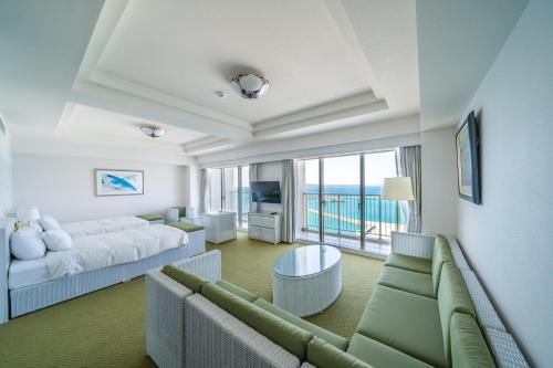 a living room with two beds and a couch at Hotel Atollemerald Miyakojima in Miyako Island