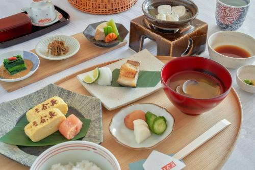 een tafel met borden eten en een kopje thee bij Sanyoan in Otofuke