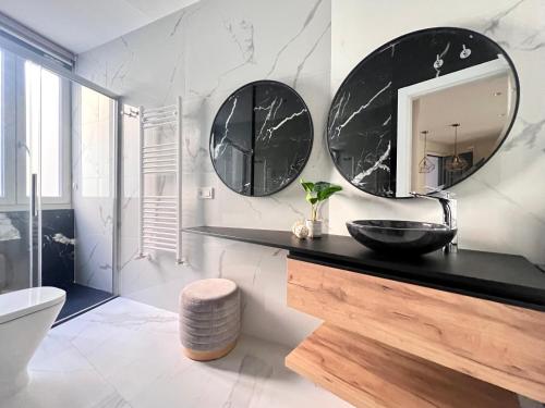 a bathroom with a sink and mirrors on the wall at Varillas Luxury Home I y II in León