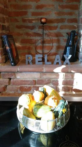 a basket of fruit in front of a brick wall at B&B Lanterna delle Fate in Asti