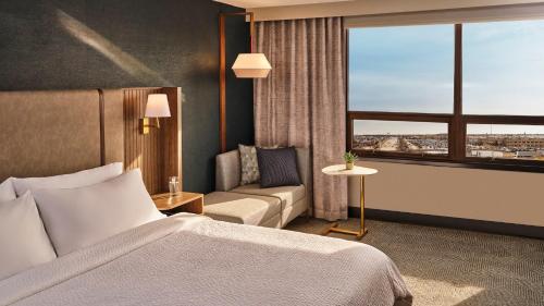 um quarto de hotel com uma cama, um sofá e uma janela em Holiday Inn Nashville Airport, an IHG Hotel em Nashville