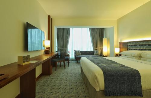 una camera d'albergo con letto e scrivania di Peshawar Serena Hotel a Peshawar