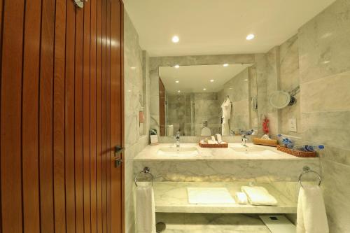 a bathroom with two sinks and a large mirror at Peshawar Serena Hotel in Peshawar