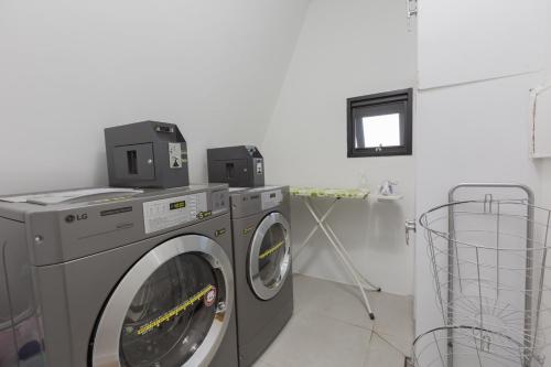 a laundry room with two washing machines and a window at Space in Blackstone in Seoul