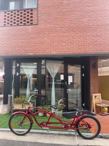 un vélo rouge garé devant un bâtiment dans l'établissement Space in Blackstone, à Séoul