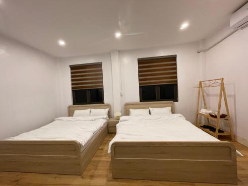 two beds in a room with two windows at Cao Bằng Siu homestay in Hoàng Ngà