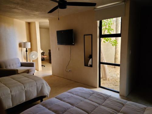 Un dormitorio con una cama y un televisor en una pared. en Casa Ramona, en Mérida