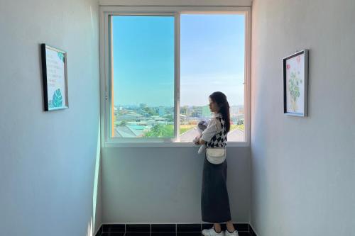 a woman standing in front of a window at Grand Sansook Omnoi in Ban Khlong Om Noi