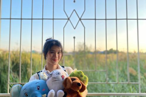a woman holding a bunch of stuffed animals at Grand Sansook Omnoi in Ban Khlong Om Noi