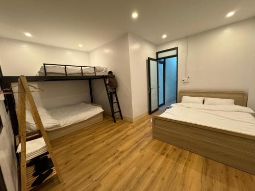 a bedroom with two bunk beds and a wooden floor at Cao Bằng Siu homestay in Hoàng Ngà