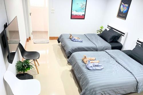 two beds with stuffed animals on them in a room at Grand Sansook Omnoi in Ban Khlong Om Noi