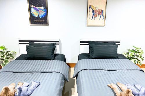 two beds sitting next to each other in a room at Grand Sansook Omnoi in Ban Khlong Om Noi