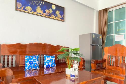 a dining room with a table and a refrigerator at Grand Sansook Omnoi in Ban Khlong Om Noi