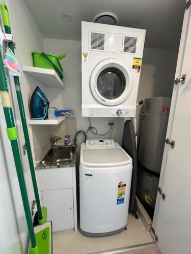 a small bathroom with a washing machine and a washer at Grand Mercure Allegra Hervey Bay in Hervey Bay