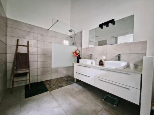 een badkamer met 2 wastafels en een spiegel bij Villa Mahogany confort, spacieuse in Le François