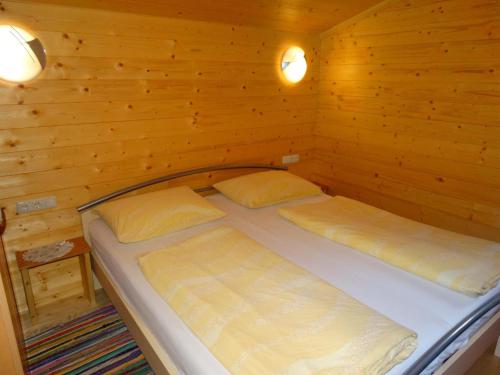 1 Schlafzimmer mit 2 Betten in einem Holzzimmer in der Unterkunft Bauernhof Sinnersberg in Kitzbühel