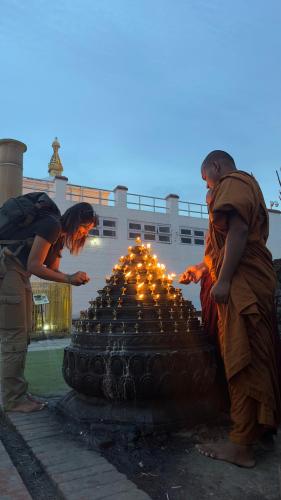 two people standing next to a fountain with lights at Hokke Lumbini in Lumbini
