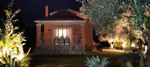a small house with a window in a yard at night at Nina's Guesthouse Corfu in Gazátika