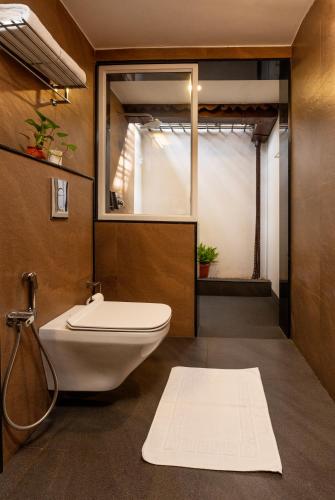 a bathroom with a white toilet and a window at Backwater Ripples Kumarakom in Kumarakom