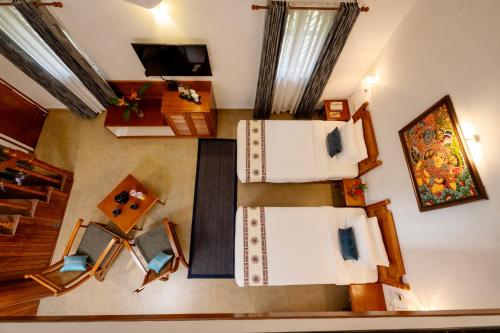 a room with two beds and a tv in it at Backwater Ripples Kumarakom in Kumarakom
