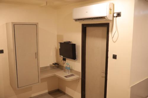 a small room with a television and a mirror at Al Zam Zam in Nagpur