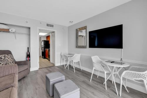 un salon avec un canapé, une table et des chaises dans l'établissement Oceanfront 1 Bedroom Dream at Camelot Resort, à Myrtle Beach