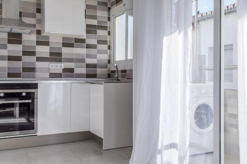 a kitchen with a sink and a washing machine at Placid Puerto in Puerto de Sagunto