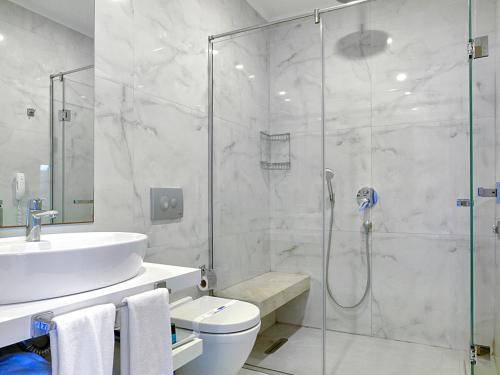 a bathroom with a shower and a toilet and a sink at Delta Hotels By Marriott Bodrum in Yalıkavak