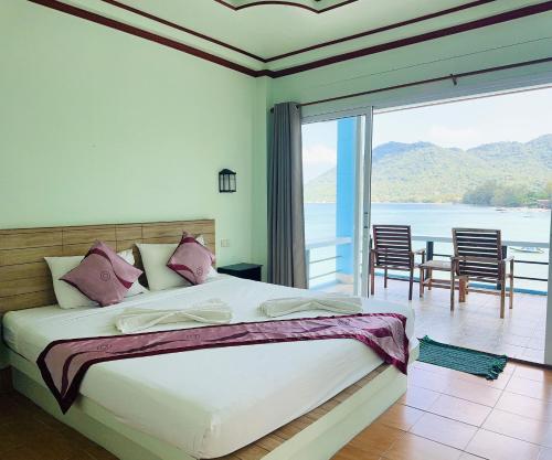 a bedroom with a bed with a view of the ocean at Ocean View Resort in Koh Tao