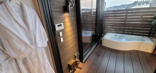 La salle de bains est pourvue d'une baignoire à côté d'une fenêtre. dans l'établissement ROMANSTAY, à Takayama