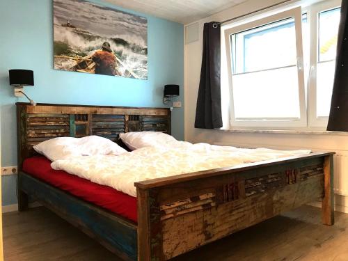 a bed in a bedroom with a window and a painting at Vordeck FW 1 in Zingst