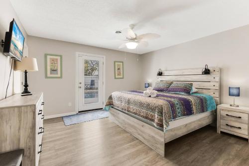 een slaapkamer met een bed en een plafondventilator bij Sunny Daze in Oak Island