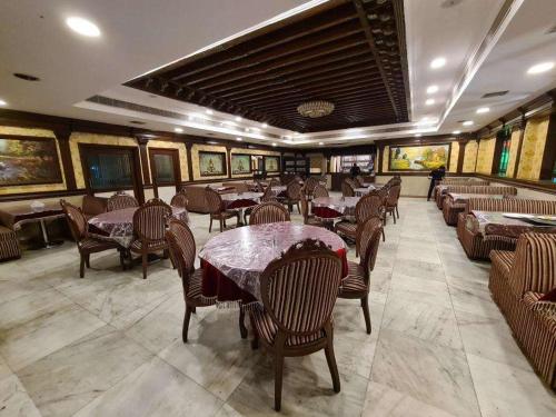 a restaurant with tables and chairs and paintings on the walls at Spacious Flat - Centrally Located in Hyderabad