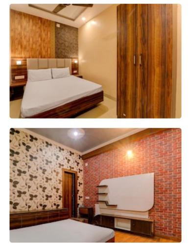 a bedroom with a bed and a brick wall at Hotel Elite in Darbhanga
