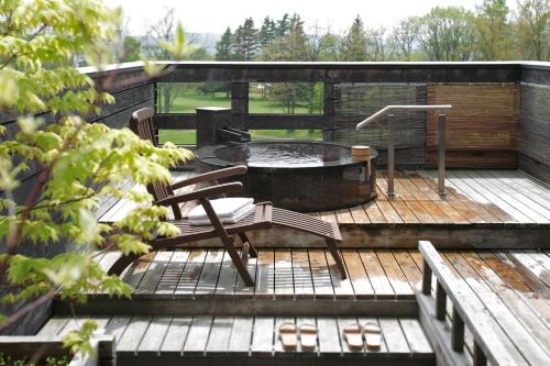 a patio with a table and chairs on a wooden deck at Sanyoan in Otofuke