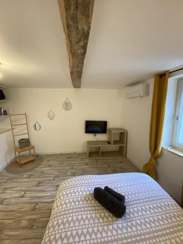 - une chambre avec un lit, une télévision et une chaise dans l'établissement Maison village rénovée tout équipée, à Saix