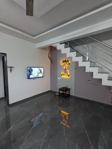 a room with a staircase and a table and an art exhibit at Akkalkot Niwas in Kolhapur