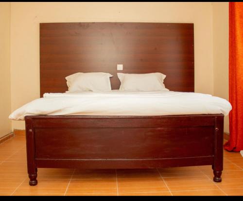 a large bed with a wooden headboard in a room at Airport View Homes in Eldoret