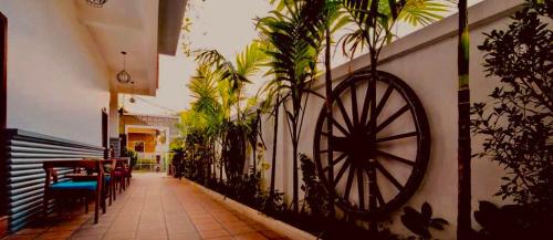 a hallway with plants and aoked wheel on a wall at Sunset View Guest House in Siem Reap