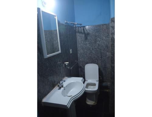 uma casa de banho com um lavatório, um WC e um espelho. em Hotel Aadhar, Barbil, Odisha em Bada Barabīl