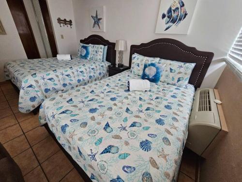 1 dormitorio con 2 camas con sábanas azules y blancas en Kodesh Vacation Club Combate, Cabo Rojo, en El Combate