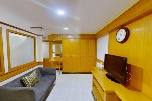 a living room with a couch and a clock on a wall at The Kaze 34 Hotel and Serviced Residence in Bangkok