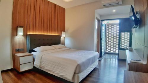 sypialnia z dużym białym łóżkiem i oknem w obiekcie Urbanview Hotel Nardis Living w mieście Ngabean